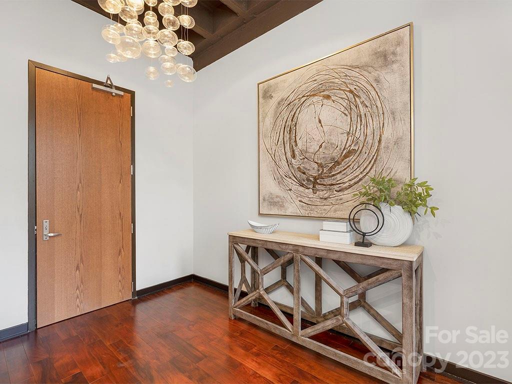 139 South Tryon Street, Unit 3B Charlotte, NC 28202 - Photo 2 of 21 a view of a room with wooden floor and a chandelier