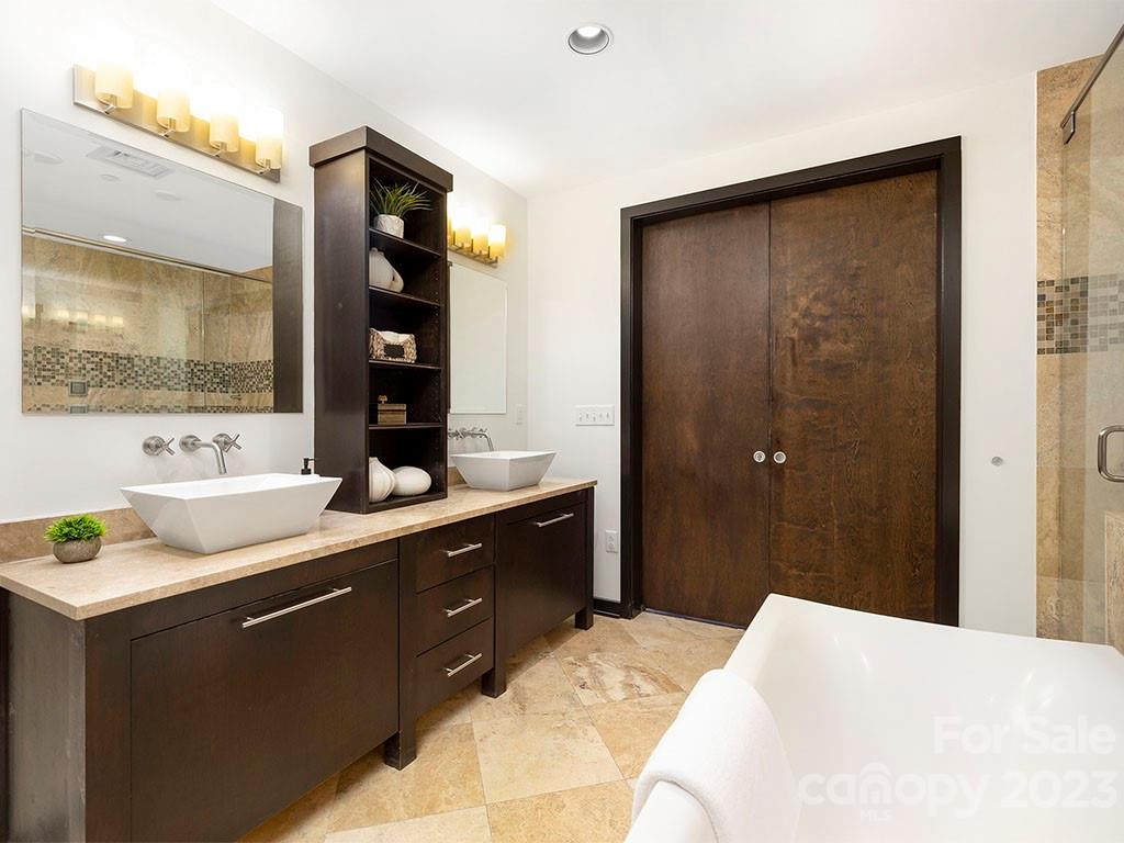 139 South Tryon Street, Unit 3B Charlotte, NC 28202 - Photo 21 of 21 a bathroom with a double vanity sink and mirror