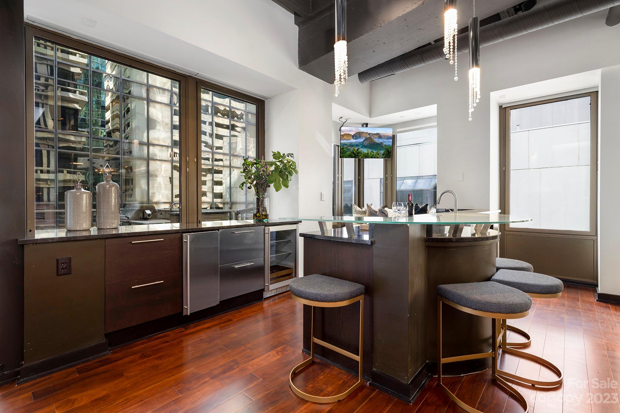 139 South Tryon Street, Unit 3B Charlotte, NC 28202 - Photo 10 of 21 a kitchen with a table chairs and wooden floor