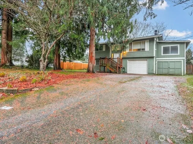 a view of a house with backyard and tree