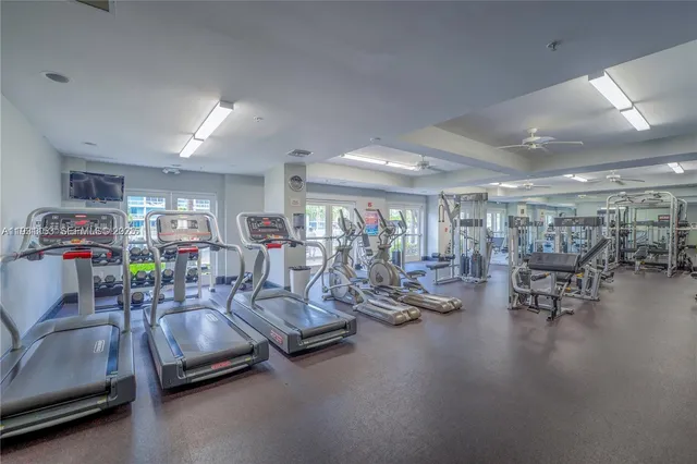 a living room with furniture pool table and large windows