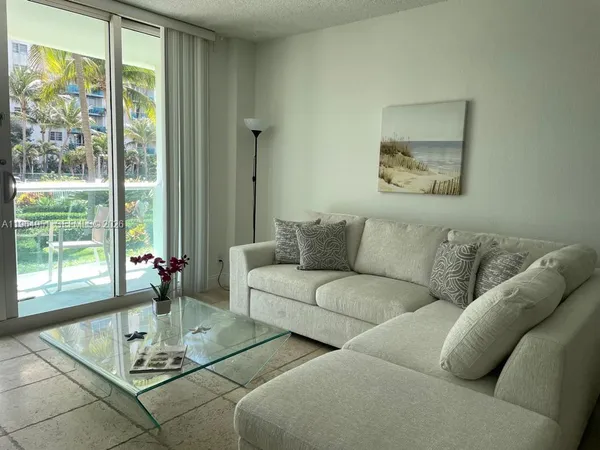 a living room with furniture and floor to ceiling windows