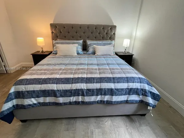 a bedroom with a bed and a night stand