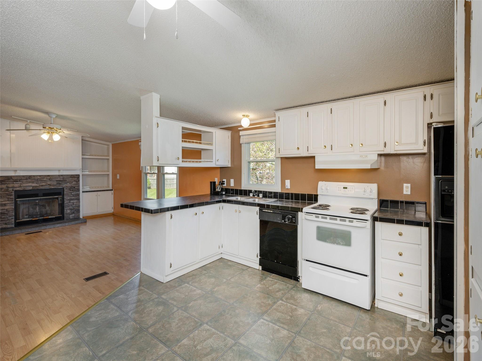 204 Cookies Way Arden, NC 28704 - Photo 9 of 22 a kitchen with granite countertop a stove top oven a sink dishwasher and a refrigerator with wooden floor