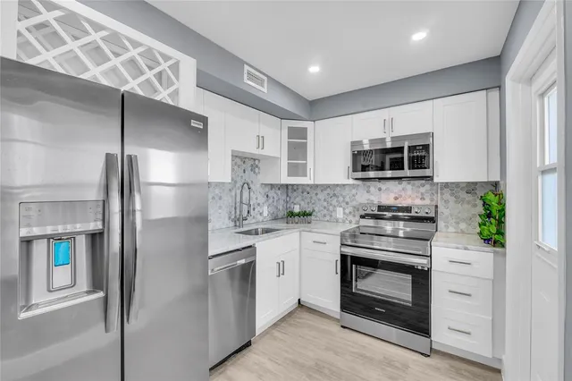 a kitchen with stainless steel appliances a stove sink microwave and refrigerator