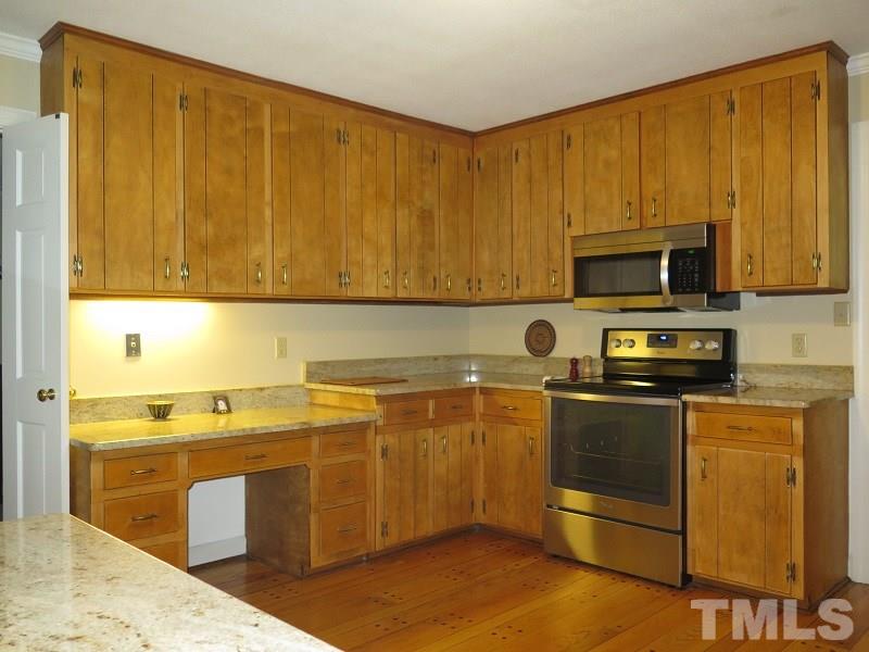 1317 Ravenhurst Drive Raleigh, NC 27615 - Photo 6 of 23 a kitchen with stainless steel appliances granite countertop a stove a sink and a microwave
