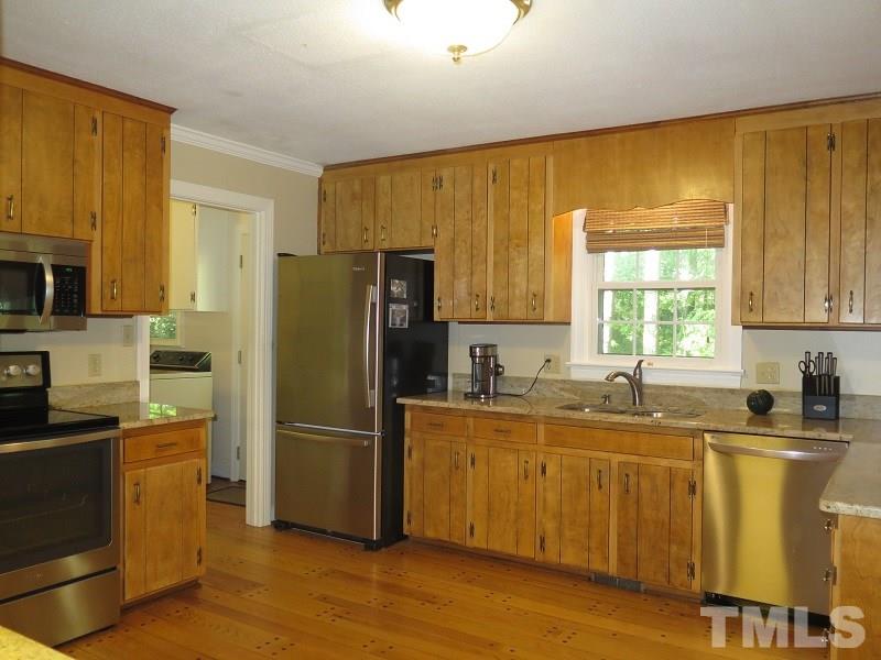 1317 Ravenhurst Drive Raleigh, NC 27615 - Photo 7 of 23 a kitchen with a sink a refrigerator and window