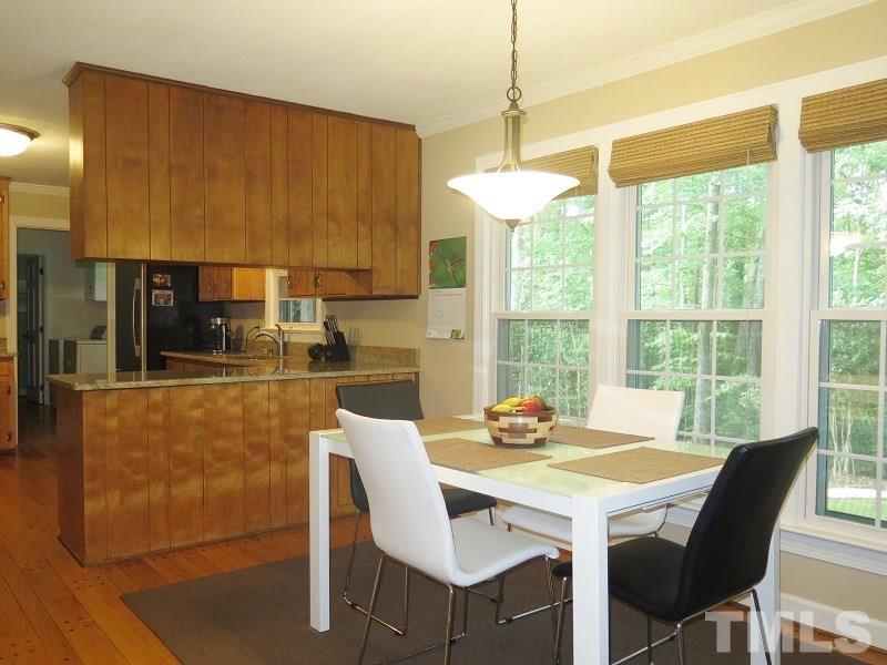1317 Ravenhurst Drive Raleigh, NC 27615 - Photo 9 of 23 a dining room with furniture a chandelier and window