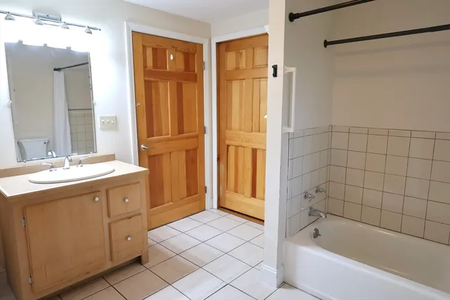 a bathroom with a tub sink and mirror