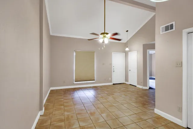 an empty room with fan and entryway