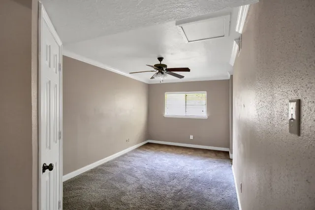 an empty room with fan and windows