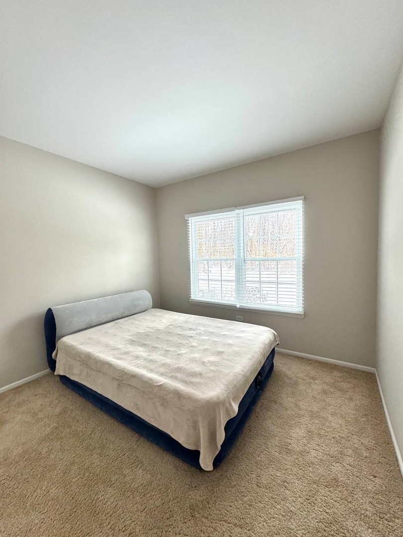 5261 Pebble Lane Crystal Lake, IL 60012 - Photo 13 of 21 a bed sitting in a bedroom next to a window