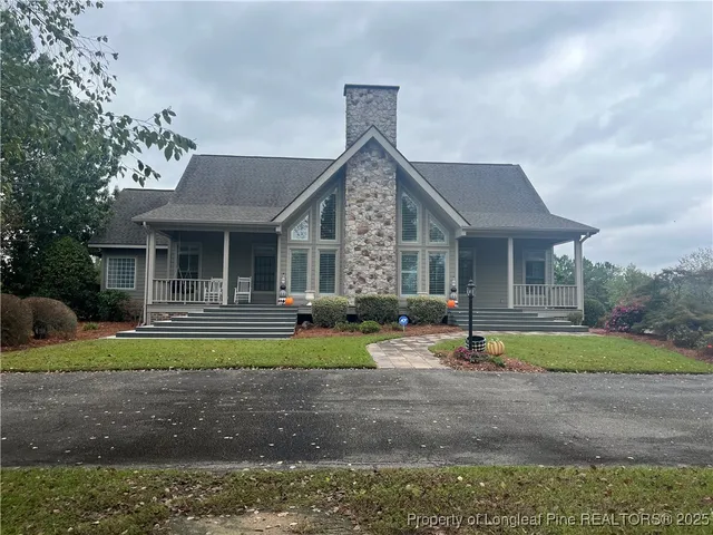 a front view of a house with a garden and trees