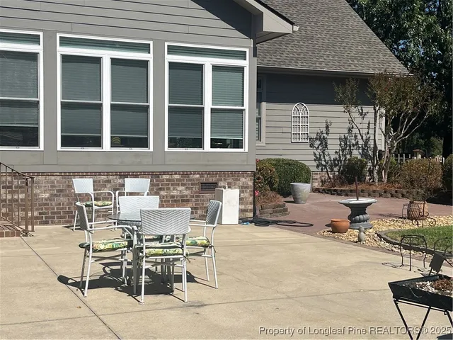 a view of a patio with table and chairs and potted plants