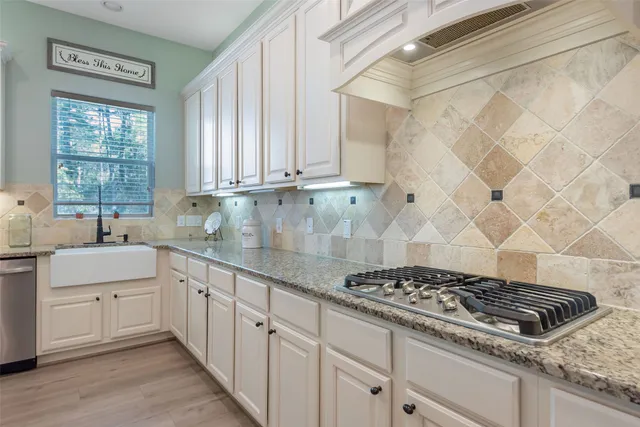 a kitchen with granite countertop a sink stove and cabinets