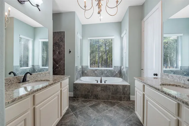 a spacious bathroom with a granite countertop tub sink and mirror