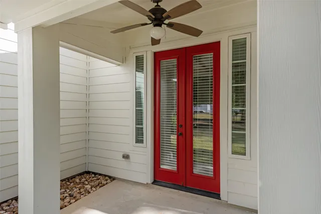 a patio with a table and chairs and potted plants
