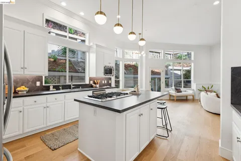 a kitchen with cabinets a stove a sink a dining table and chairs