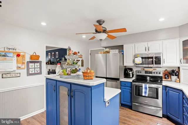 a kitchen with stainless steel appliances a stove a refrigerator cabinets and wooden floor