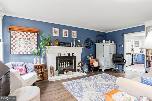 a living room with furniture a fireplace and a large window