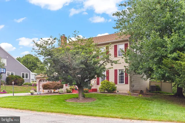 a view of a big house with a big yard and large trees