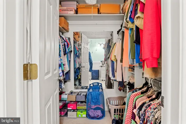 a view of walk in closet with clothes and shoes
