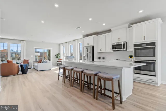 a large kitchen with kitchen island a stove a sink a dining table and chairs