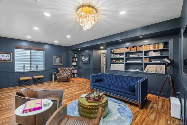 a living room with furniture a piano and a bookshelf