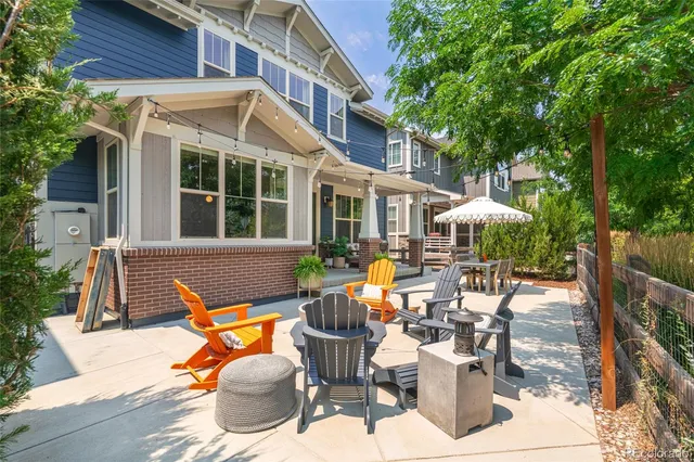 a view of a patio with table and chairs potted plants with wooden floor and fence
