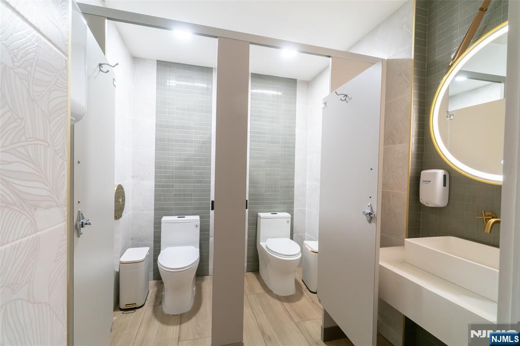 72-74 Elm Road Newark, NJ 07105 - Photo 18 of 41 a bathroom with a granite countertop toilet a sink and a mirror