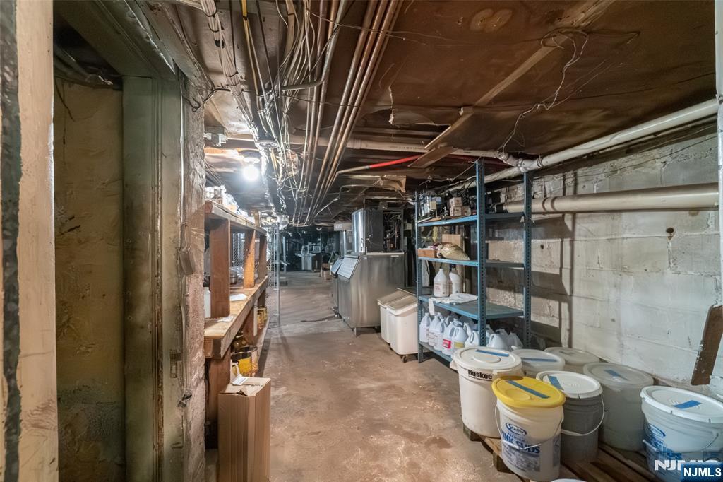 72-74 Elm Road Newark, NJ 07105 - Photo 30 of 41 a view of a storage room with water heater and racks on the wall