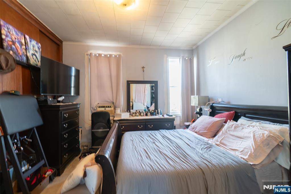 72-74 Elm Road Newark, NJ 07105 - Photo 37 of 41 a bedroom with a bed a flat screen tv and a large window