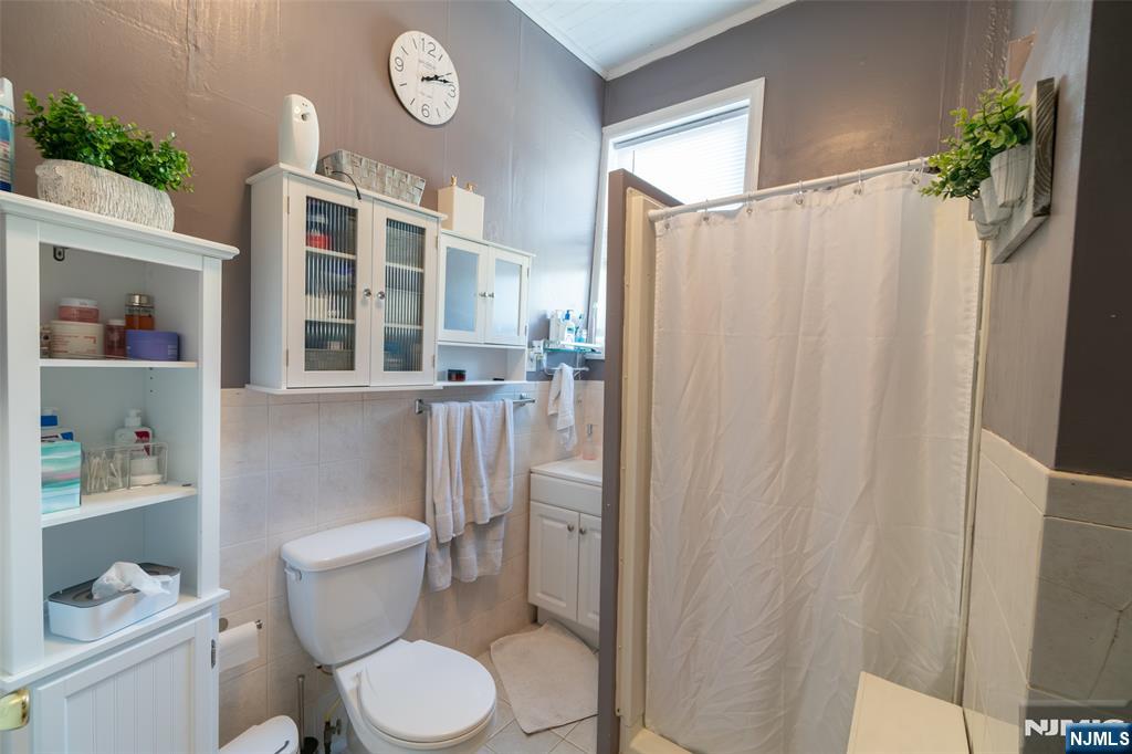 72-74 Elm Road Newark, NJ 07105 - Photo 39 of 41 a white toilet sitting next to a bathroom sink and a shower