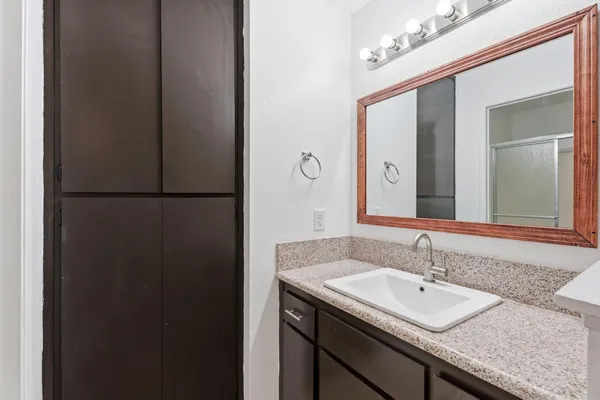 a bathroom with a granite countertop sink and a mirror