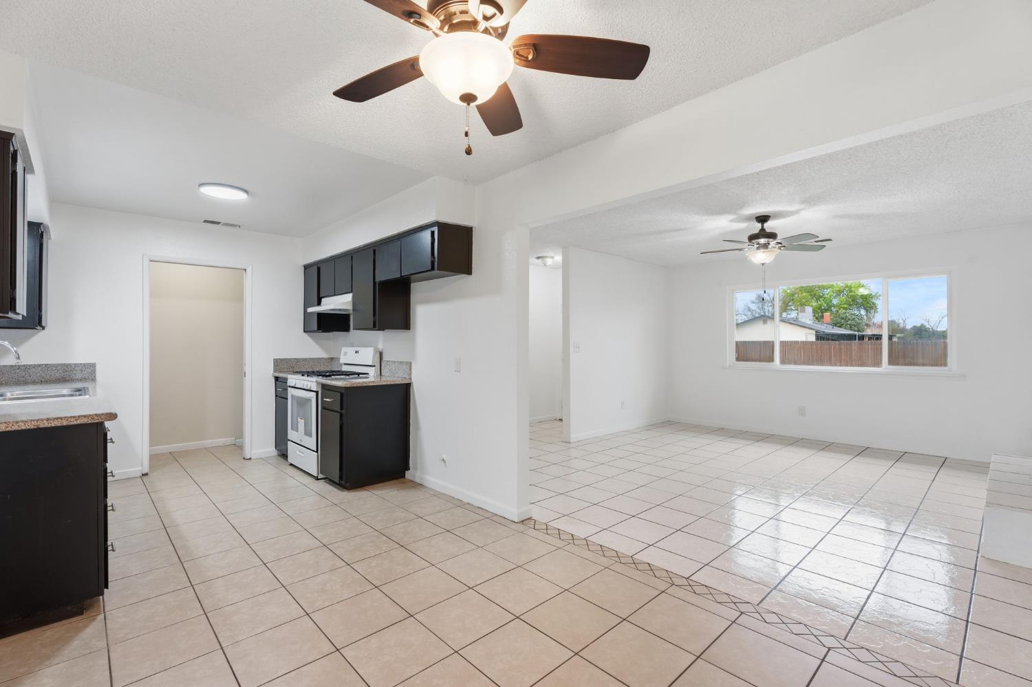 237 East Modoc Avenue Visalia, CA 93291 - Photo 27 of 31 a large kitchen with stainless steel appliances kitchen island granite countertop a refrigerator and a stove top oven