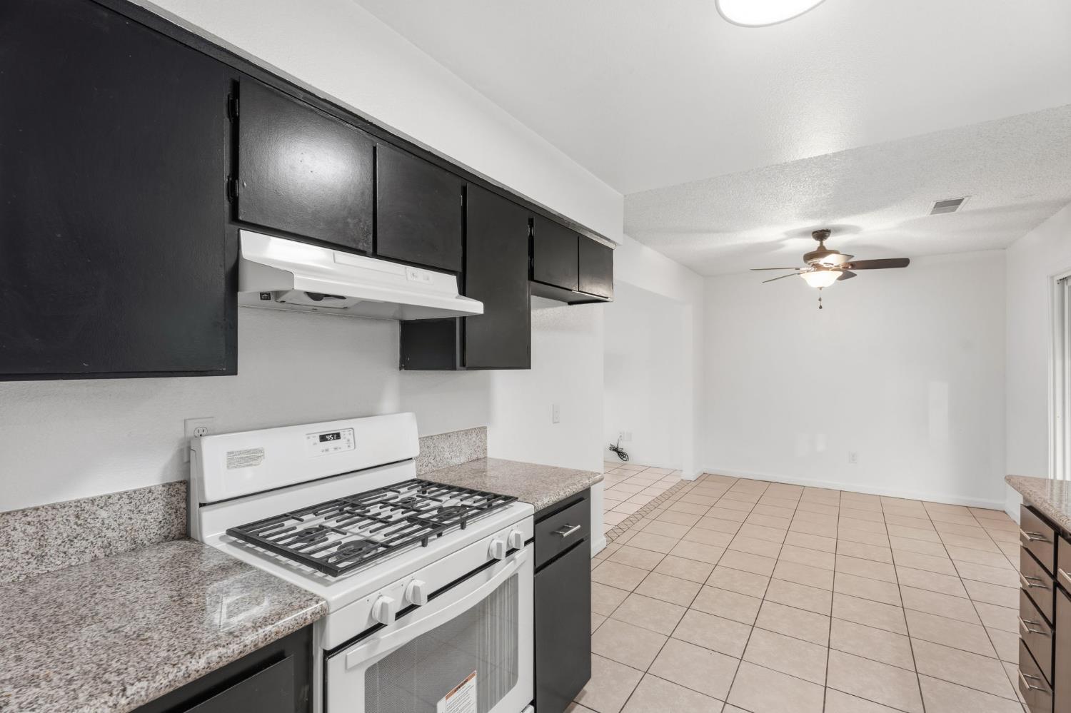 237 East Modoc Avenue Visalia, CA 93291 - Photo 4 of 31 a kitchen with granite countertop a stove and a sink
