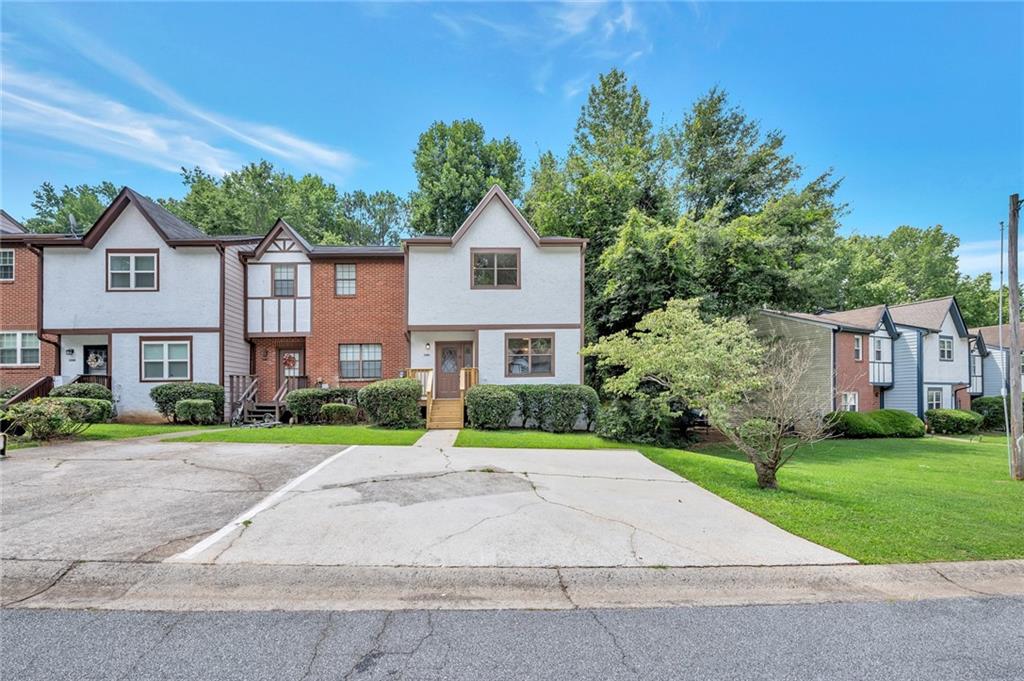 a front view of a house with a yard and trees