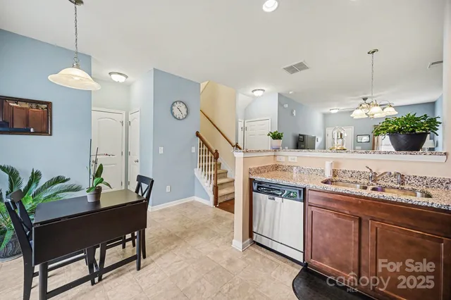 a kitchen with stainless steel appliances a sink a stove a refrigerator a center island and a wooden floor