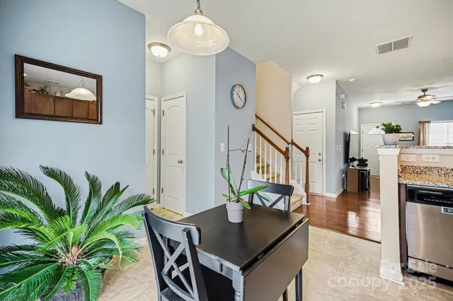 a dining room with furniture potted plants and wooden floor