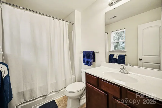 a bathroom with a sink a toilet and shower curtain