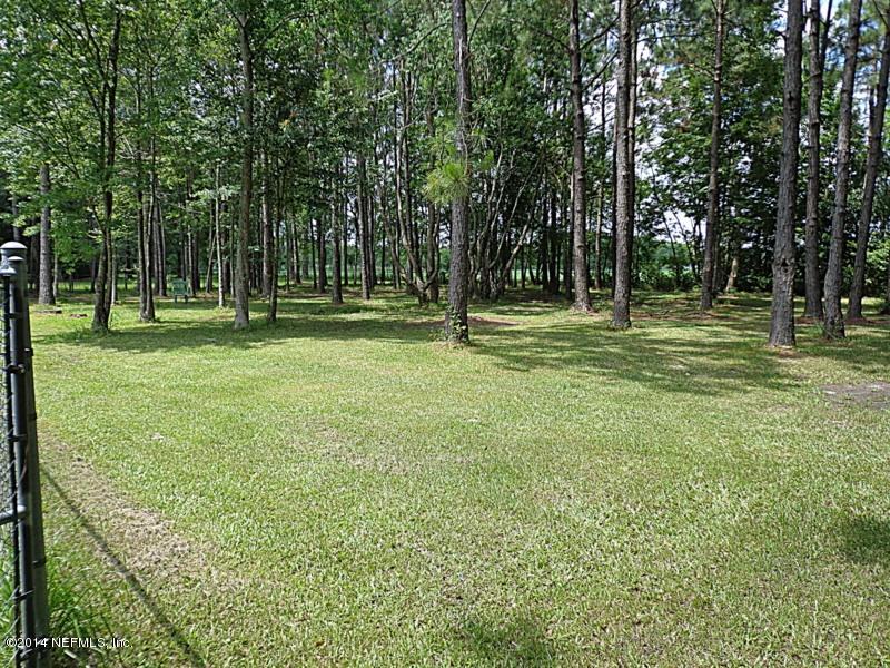 54399 Church Road Callahan, FL 32011 - Photo 12 of 49 a backyard of a house with trees and outdoor seating