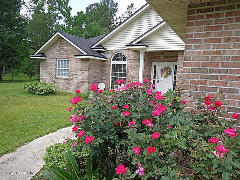 54399 Church Road Callahan, FL 32011 - Photo 20 of 49 a front view of a house with a big yard and potted plants