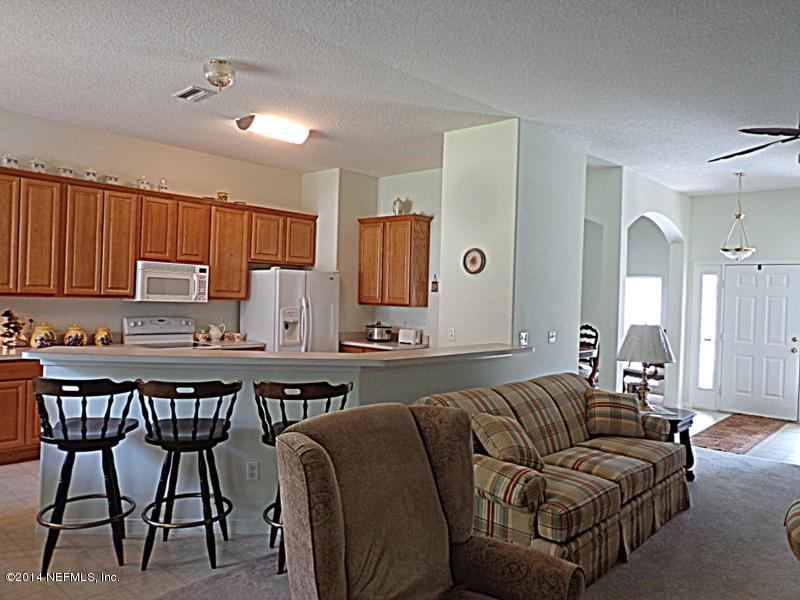 54399 Church Road Callahan, FL 32011 - Photo 25 of 49 a living room with stainless steel appliances kitchen island granite countertop furniture and a refrigerator