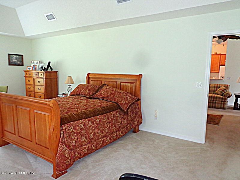 54399 Church Road Callahan, FL 32011 - Photo 38 of 49 a bed sitting in a bedroom next to a cabinet