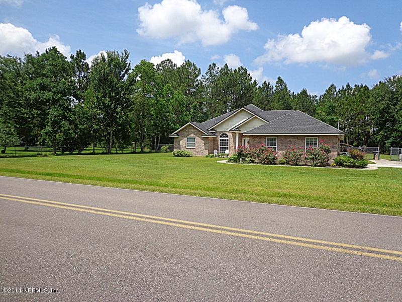 54399 Church Road Callahan, FL 32011 - Photo 4 of 49 a front view of a house with a yard and garage