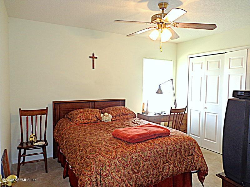 54399 Church Road Callahan, FL 32011 - Photo 48 of 49 a bedroom with a bed and a chair
