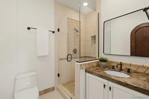 a bathroom with a granite countertop sink a mirror and shower