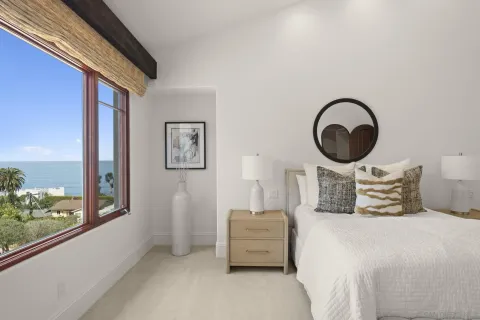 a bedroom with bed and a large window