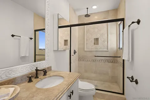 a bathroom with a granite countertop sink toilet and shower