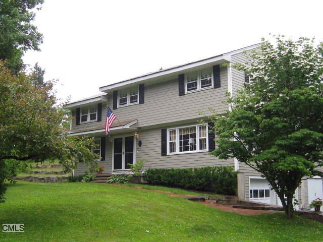 87 Ridgebury Road Ridgefield, CT 06877 - Photo 1 of 1 a front view of a house with a garden